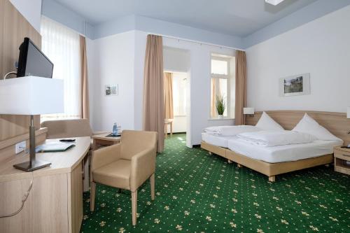 um quarto de hotel com uma cama, uma secretária e uma cadeira em Hotel Brockenscheideck em Schierke