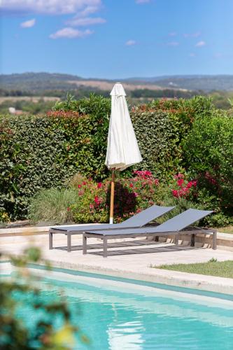 a umbrella and a bench next to a swimming pool at Mas Coeur Provence Calme Beauté Grand Parc in Pernes-les-Fontaines