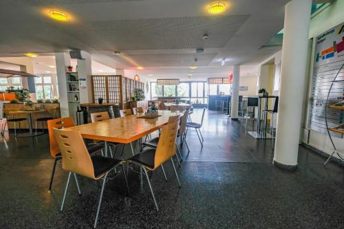 a dining room with a wooden table and chairs at Jugendherberge Stuttgart International in Stuttgart