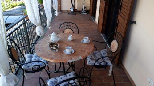 uma pequena mesa e cadeiras numa varanda em Porzione villetta in residence em Pescia Romana