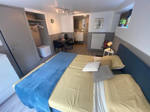 1 dormitorio con 1 cama grande con manta azul en Route 123 Birchwood Pension en Kortessem