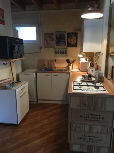 a kitchen with white cabinets and a stove top oven at Boutonne Rouge Gite in Bouin