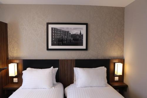 a hotel room with two beds and a picture on the wall at Harbour Spring, Peterhead by Marston's Inns in Peterhead