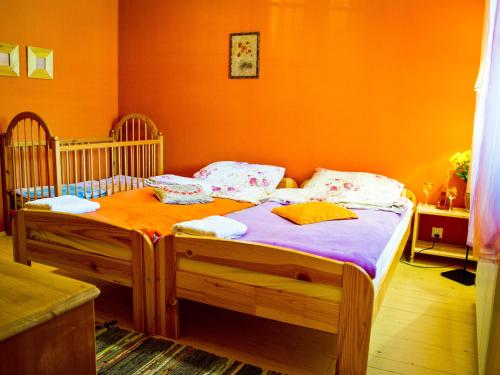 1 dormitorio con 2 camas individuales y pared de color naranja en Karkonoskie Siodło, en Kostrzyca