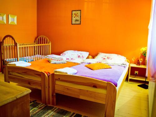 sypialnia z 2 łóżkami pojedynczymi i pomarańczową ścianą w obiekcie Karkonoskie Siodło w mieście Kostrzyca