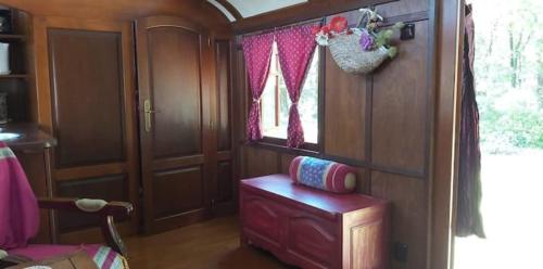 une chambre avec une chaise et une fenêtre dans un train dans l'établissement La roulotte d'alany, à Grayan-et-lʼHôpital
