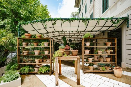 a garden with potted plants and a pergola at Palazzo BelVedere in Montecatini Terme