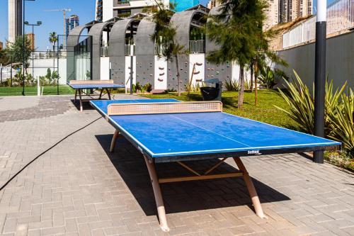 two ping pong tables sitting on a sidewalk at SUNSET WAVES blue sky apartment in Benidorm