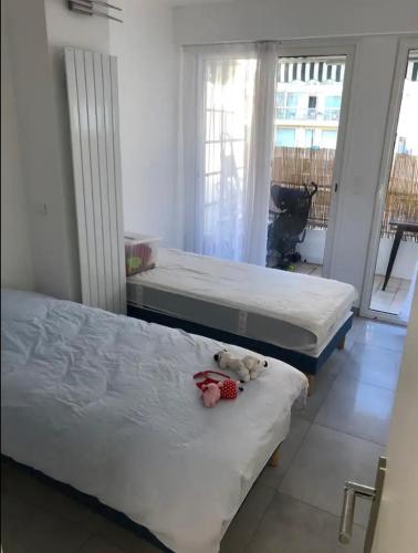 - deux lits dans une chambre avec un ours en peluche dans l'établissement Impeccable 3 pièces avec balcons, la plage à 50m Juan les pins proche Cannes, à Antibes