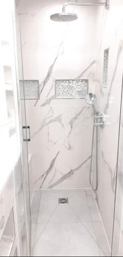 une salle de bain avec une douche avec une porte vitrée dans l'établissement Impeccable 3 pièces avec balcons, la plage à 50m Juan les pins proche Cannes, à Antibes