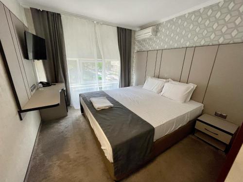 a bedroom with a large bed and a window at Hotel Cosmos in Ruse