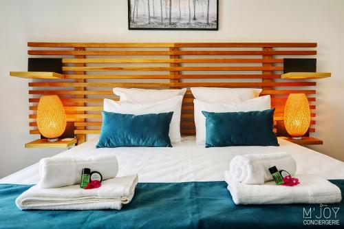 a bedroom with a large bed with towels on it at TIGOUYA - Maison 135m2 - 2 ch et Jacuzzi in Saint-Leu