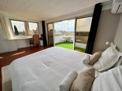 - une chambre avec un grand lit blanc et une grande fenêtre dans l'établissement Tutto Mio, à Villeneuve-lès-Avignon