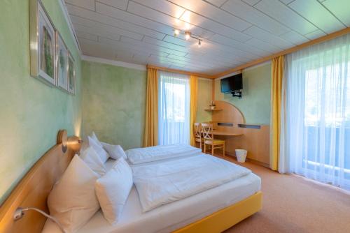 ein Schlafzimmer mit einem Bett und einem Tisch darin in der Unterkunft Frühstückspension Haus Ahamer in Ebensee