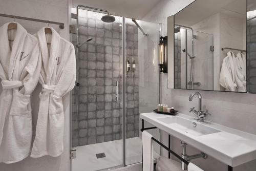 a bathroom with a sink and a shower with towels at Vincci Molviedro Suites Apartments in Seville