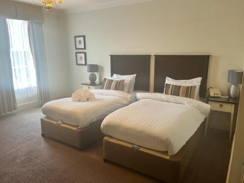 a bedroom with two beds and a window at Park House Hotel in Shifnal