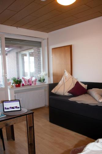 a living room with a couch and a table with a laptop at Gästewohnung Mönchengladbach in Mönchengladbach