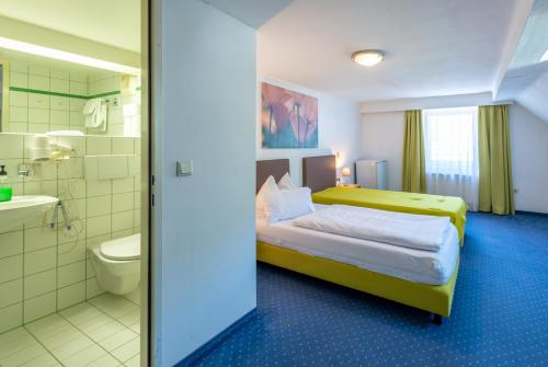een hotelkamer met een bed en een badkamer bij Frühstückspension Haus Ahamer in Ebensee