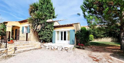 a house with a palm tree in front of it at Suite Oasis en Provence Luberon Pierrevert in Pierrevert