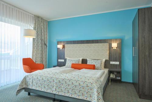 A bed or beds in a room at Trans World Hotel Auefeld