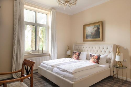 a bedroom with a large white bed with a window at Hotel & Restaurant Raueneck in Bad Saarow