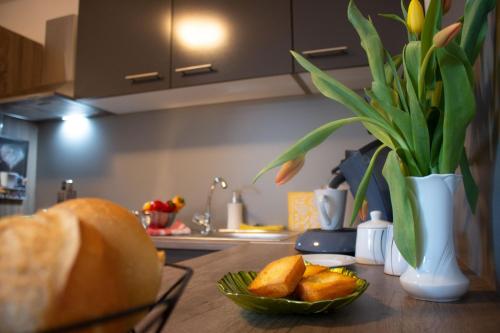 a table with a bowl of bread and a vase with a plant at Gästewohnung Mönchengladbach in Mönchengladbach