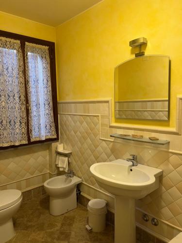 bagno con lavandino, servizi igienici e specchio di Le Boccede Country House B&B a Villa Minozzo