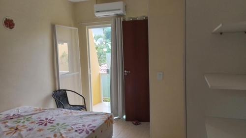 - une chambre avec un lit et une porte donnant sur un balcon dans l'établissement Casa em Imbassai, à Imbassaí