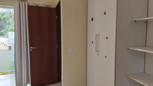 a room with a closet with a door and shelves at Casa em Imbassai in Imbassai