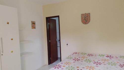 a bedroom with a bed and a door with a clock at Casa em Imbassai in Imbassai