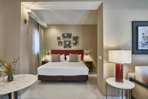 Habitación de hotel con 1 cama y 2 mesas en Vincci Molviedro Suites Apartments en Sevilla