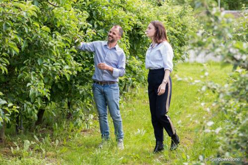 a man and a woman standing next to a tree at Arbulé Agriturismo & Spa Valtellina in Poggiridenti