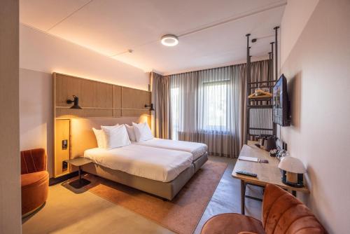 Habitación de hotel con cama y escritorio en Notiz Hotel Leeuwarden, en Leeuwarden