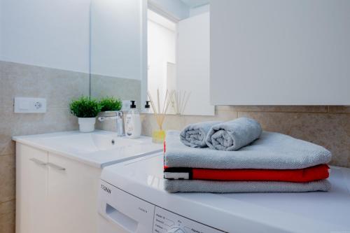 biała łazienka z zestawem ręczników na ladzie w obiekcie Bright & Stylish Apartment in Chipeque, Los Cristianos w Aronie