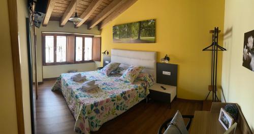 um quarto com uma cama num quarto com paredes amarelas em Casa da Cota em Monterroso