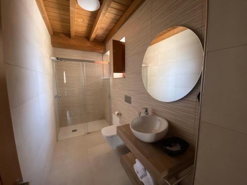 a bathroom with a sink and a toilet and a mirror at Casa da Cota in Monterroso