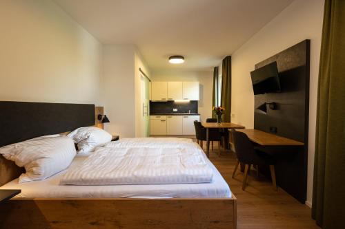 een slaapkamer met een groot bed en een tafel met stoelen bij HeindlHof in Ingolstadt