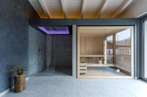 a bathroom with a shower and a glass door at Arbulé Agriturismo & Spa Valtellina in Poggiridenti