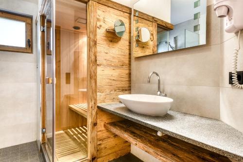 a bathroom with a sink and a shower at Uralp Royal by A-Appartments in Brand