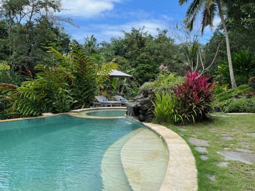 uma piscina num quintal com árvores e plantas em Balian Bliss Retreat Bungalow & Villas em Balian