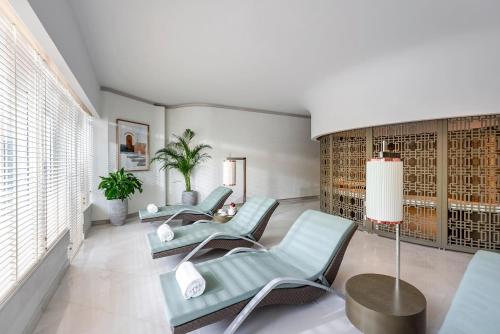 a living room with three chairs and a table at Pullman Doha West Bay in Doha