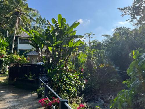 a garden with a house and a stream at Balian Bliss Retreat Bungalow & Villas in Balian