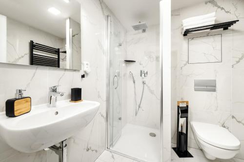 a white bathroom with a sink and a shower at Apartmány Horská, Vrchlabí in Vrchlabí