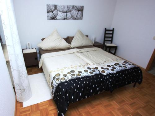 une chambre avec un lit avec une couette noire et blanche dans l'établissement Seepark Falk Wohnung Nr -2-, à Fribourg-en-Brisgau