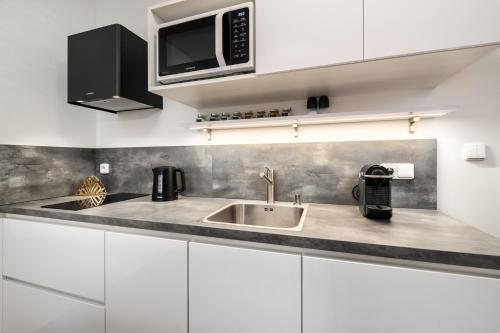 a kitchen with a sink and a microwave at Apartmány Horská, Vrchlabí in Vrchlabí