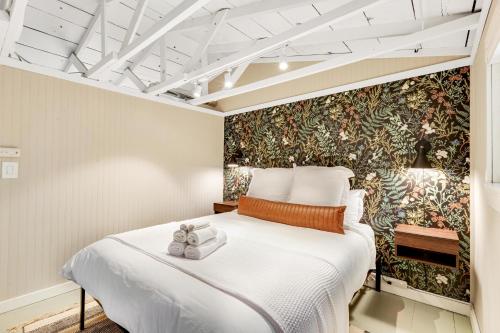 een slaapkamer met een groot wit bed en een muurschildering bij Sunset Chalet at Lake Alice in Fall City