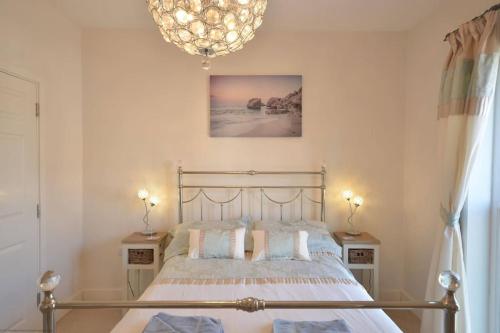 a bedroom with a bed and a chandelier at Pebble House (Goring-by-Sea) in Worthing