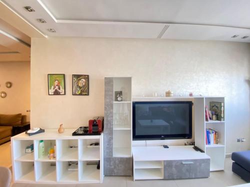 a living room with a tv and a white entertainment center at Residence Boule d'OR- EMPLACEMENT - NETFLIX - FREE PARKING in Casablanca