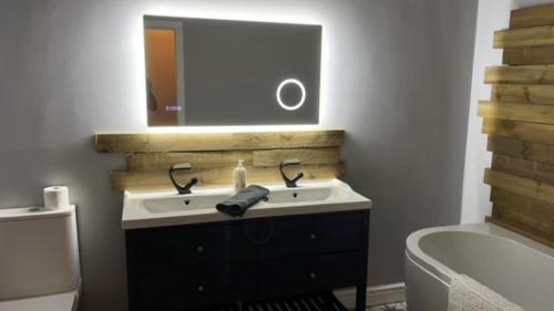 ein Badezimmer mit einem Waschbecken, einem Spiegel und einer Badewanne in der Unterkunft Ashley Place in Southport