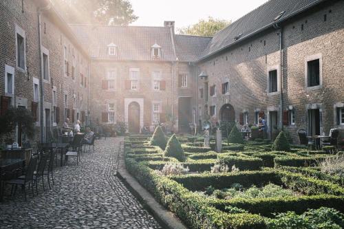 a courtyard with a garden and people sitting at tables at Meschermolen 2 in Eijsden